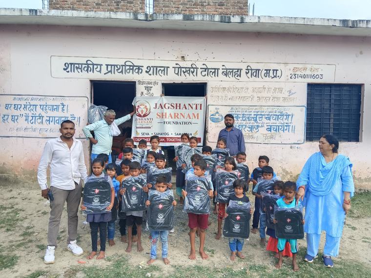 Children with their new school bags, volunteers and teachers outside the school, with the foundation banner (photo 10 of 10)