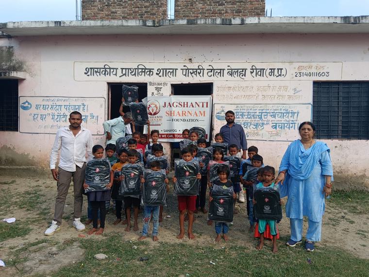 Children with their new school bags, volunteers and teachers outside the school, with the foundation banner (photo 9 of 10)