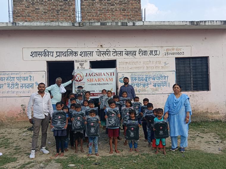 Children with their new school bags, volunteers and teachers outside the school, with the foundation banner (photo 7 of 10)