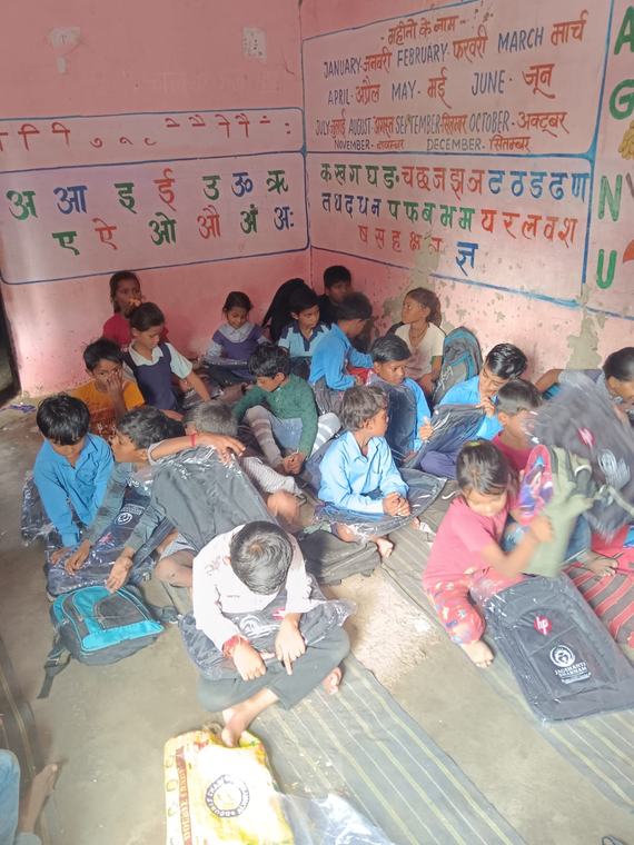 Children sitting on the classroom floor with their new school bags (photo 6 of 10)