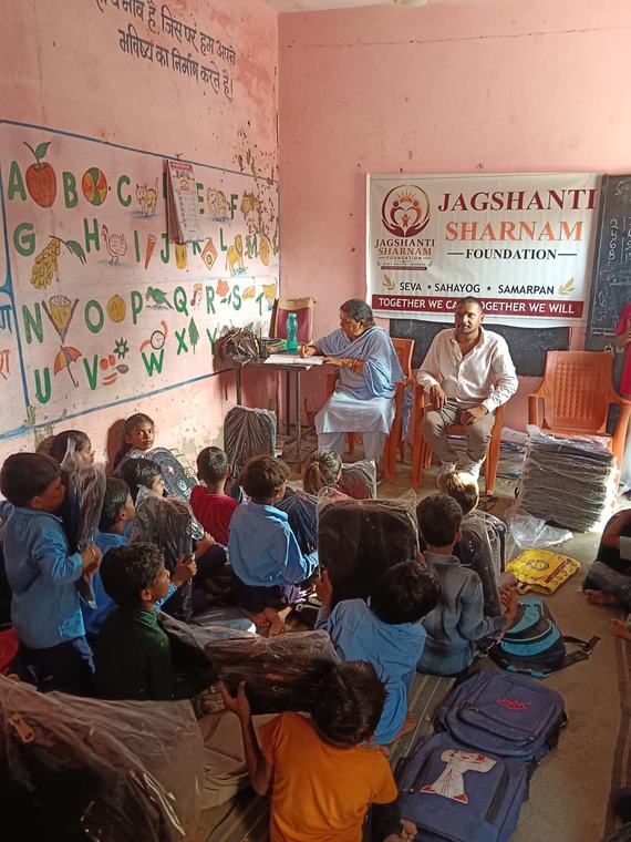 Foundation team seated in a classroom with children listening on the floor