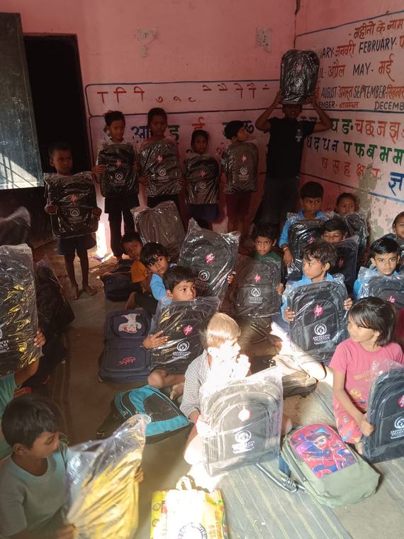 Children in the classroom holding up their new school bags
